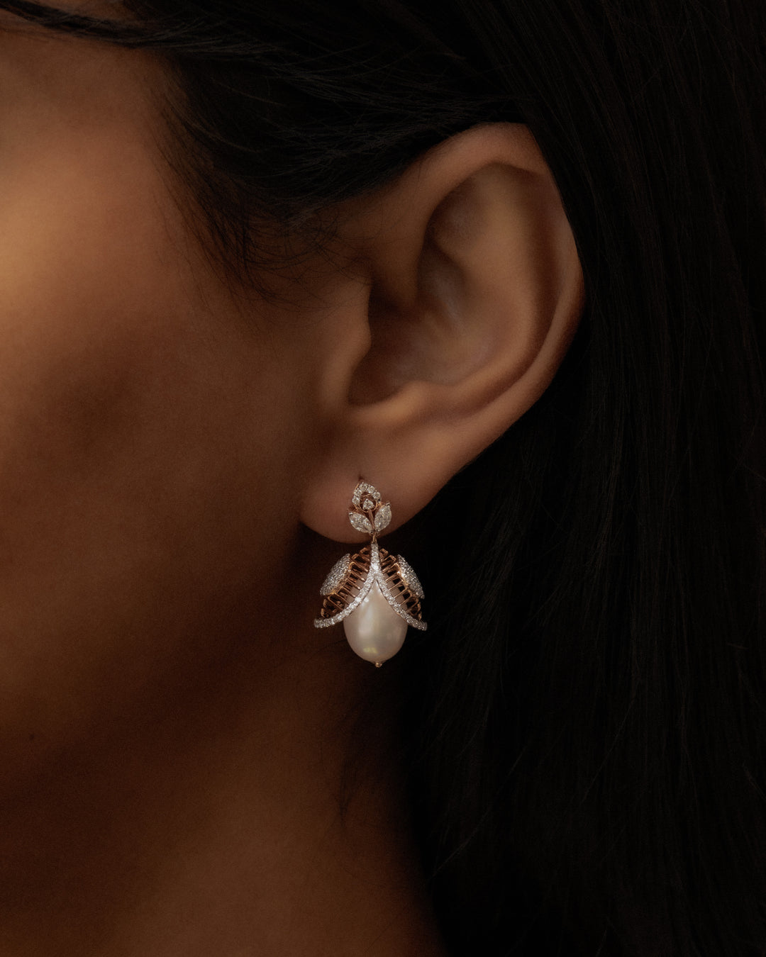 Close-up of an ear wearing a decorative earring with a dark background